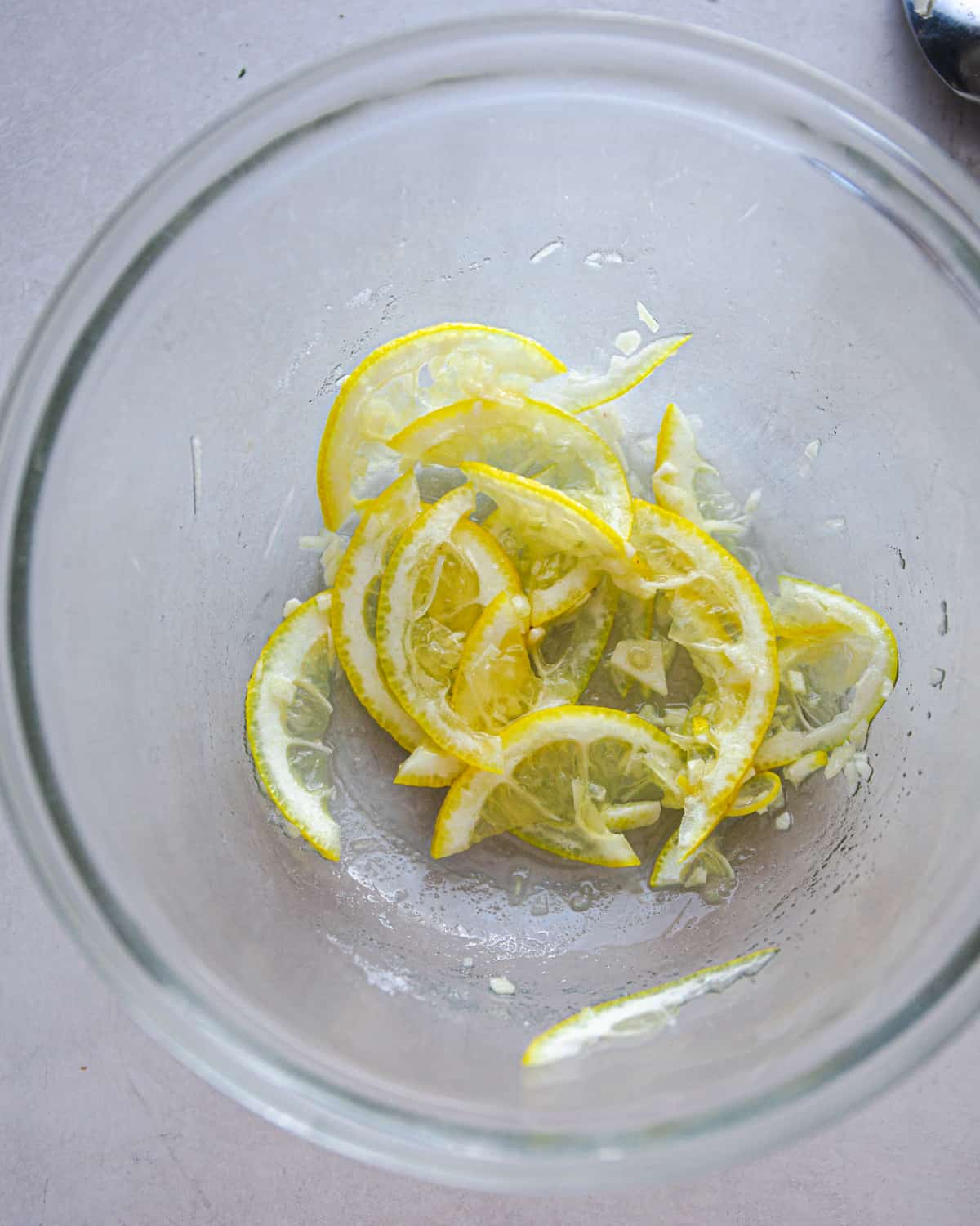 thin lemon slices and garlic in a glass bowl