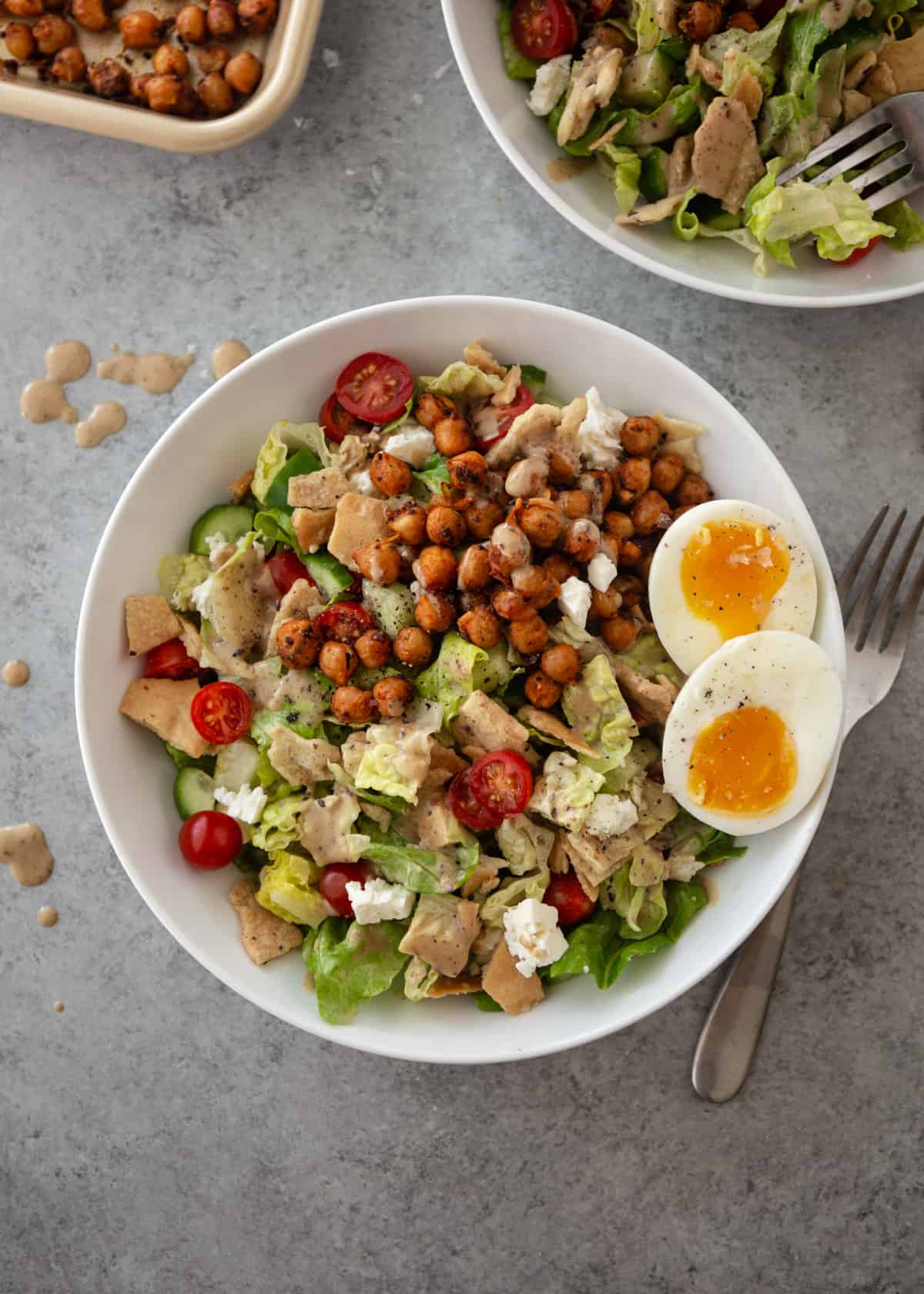 overhead image of salad with boiled eggs, chickpeas and feta in a white bowl