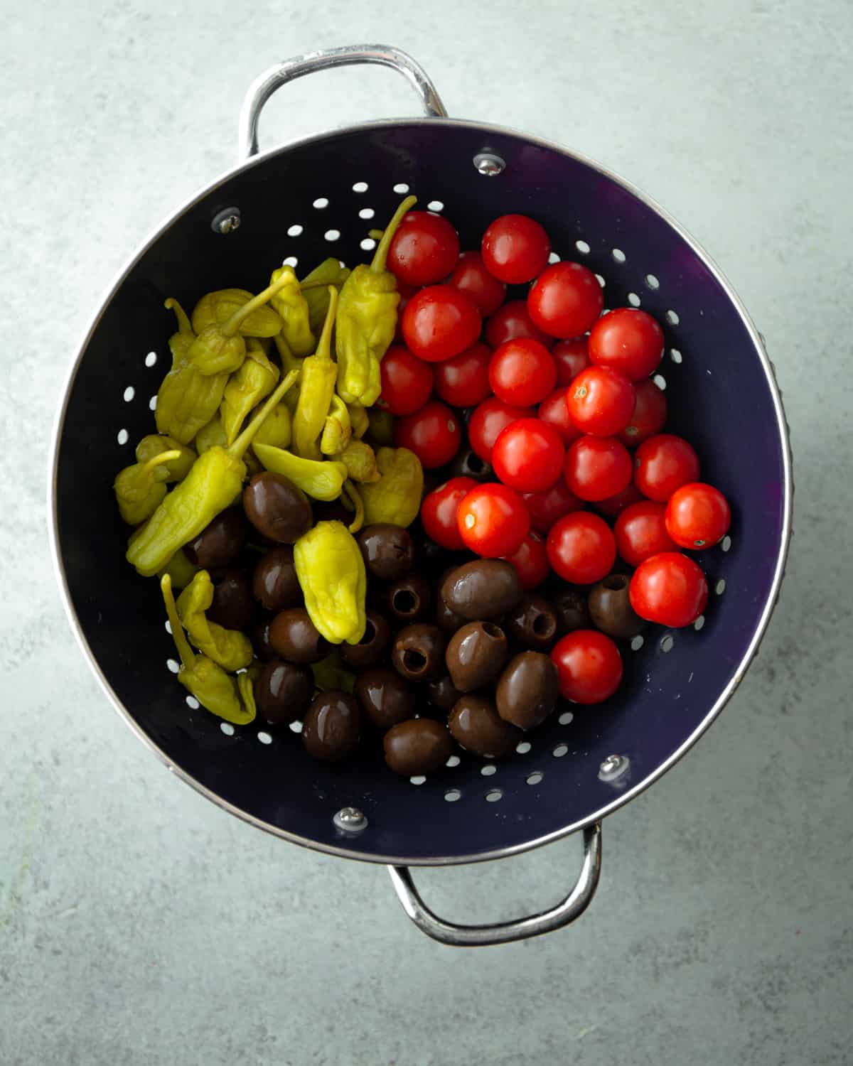 tomatoes, peppers and olives in a colander
