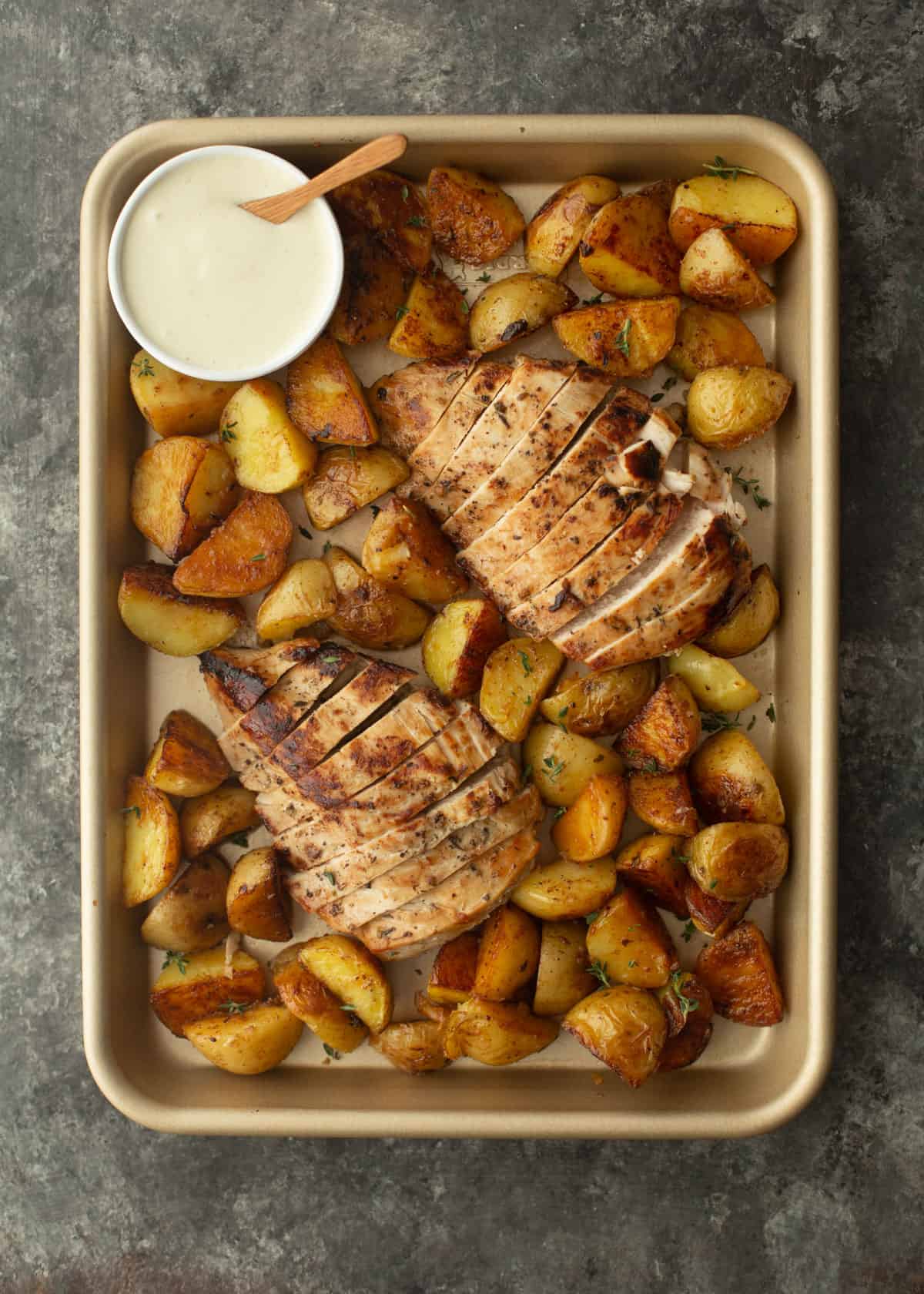 potatoes and herb marinated chicken on a sheet pan