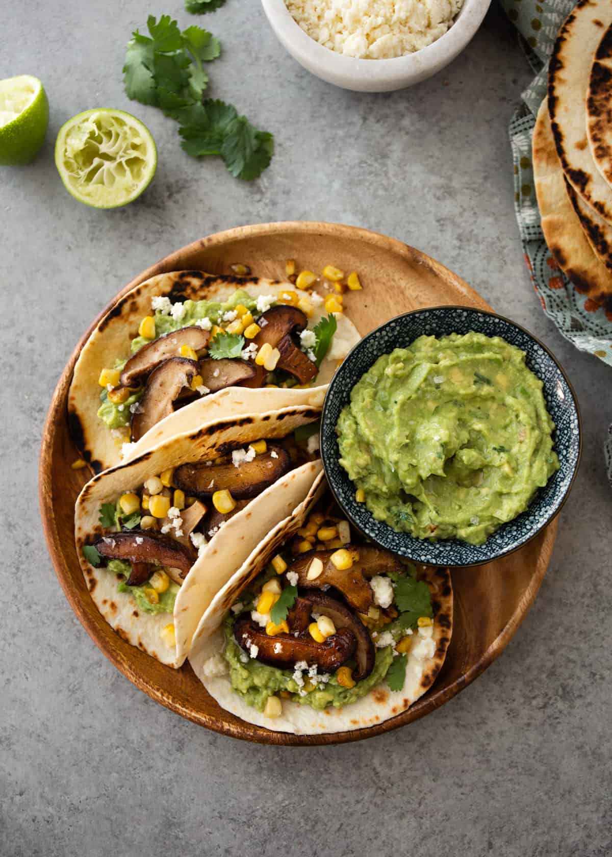 overhead image of tacos and guacamole on a wooden plate