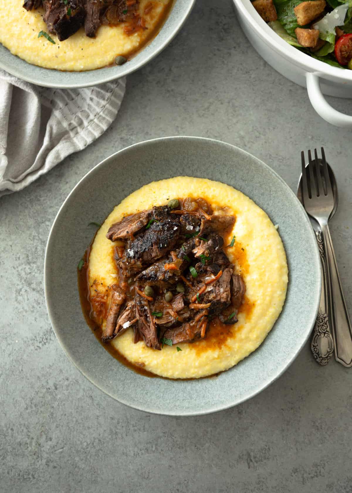 pot roast over polenta in a grey bowl