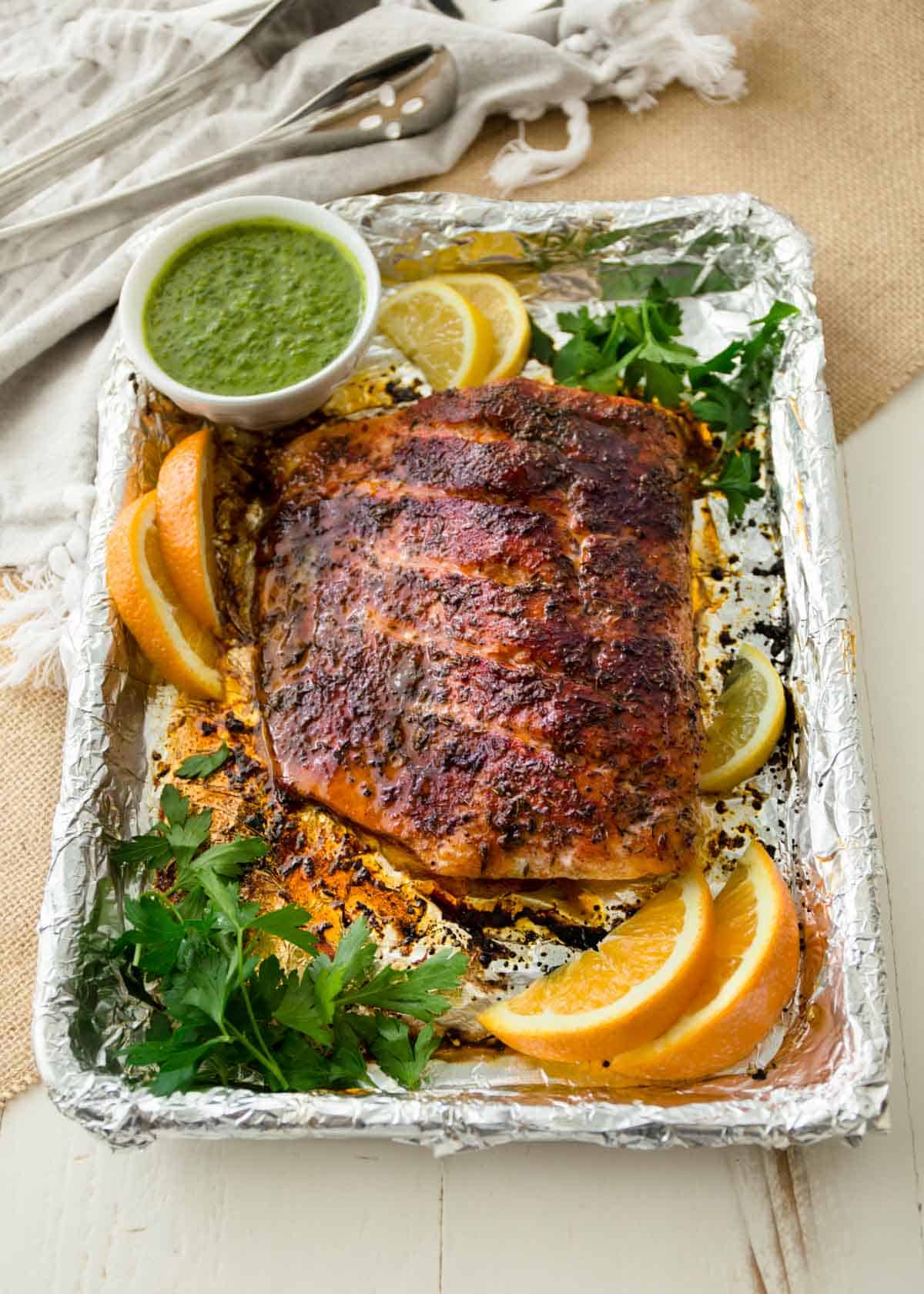 blackened salmon with citrus salmon verde on a foil lined sheet pan