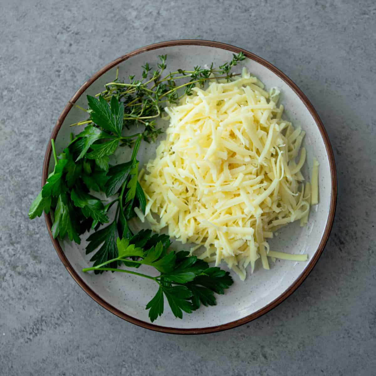 herbs and shredded cheese on a white plate