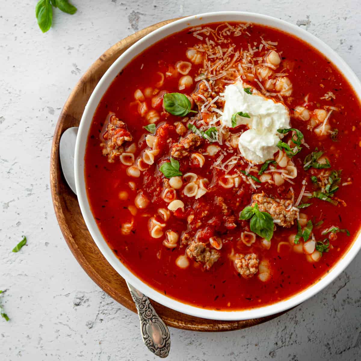 tomato and sausage soup in a white bowl