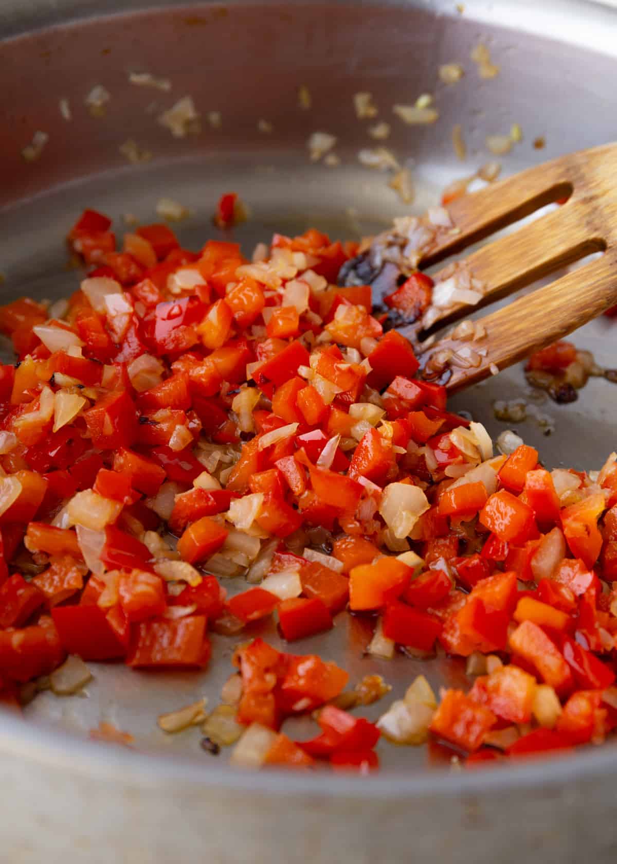 peppers and onions cooking in a saute pan