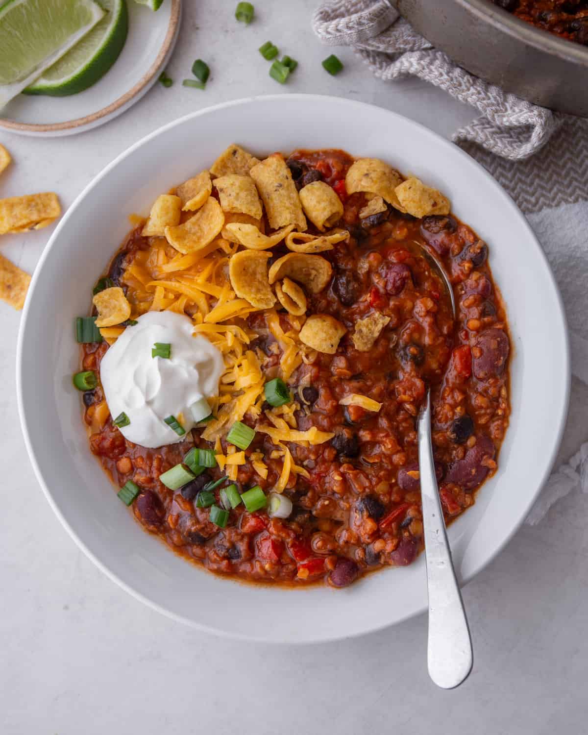 lentil chili in a white bowl with a spoon