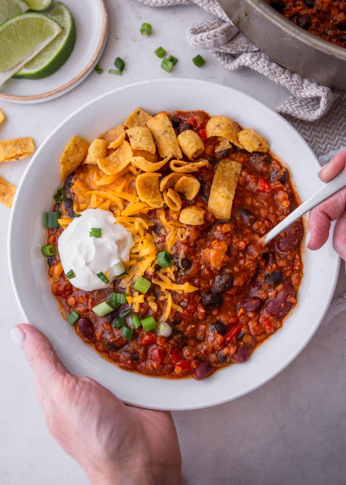 lentil chili in a white bowl with a spoon