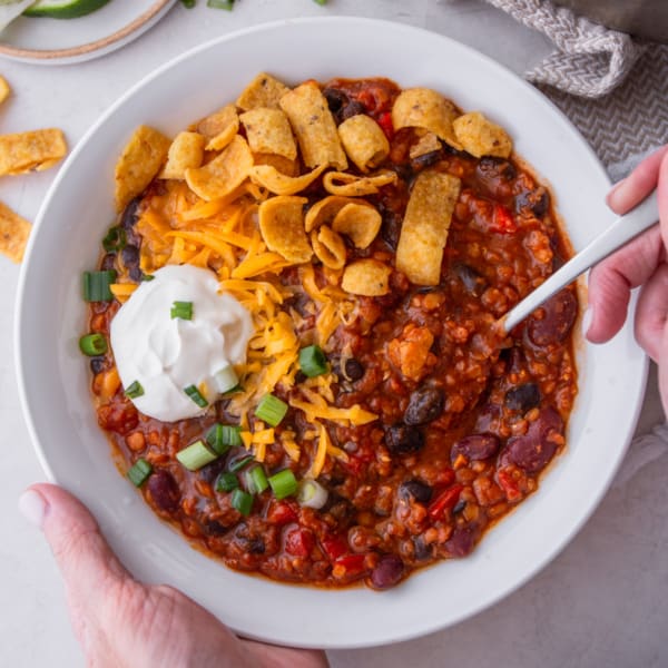 lentil chili in a white bowl with a spoon