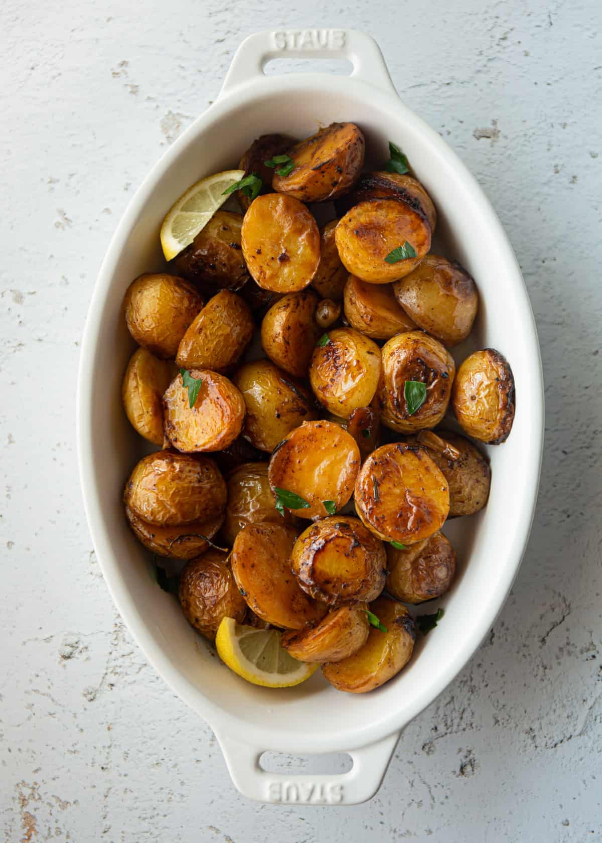 overhead image of roasted potatoes in a white baking dish