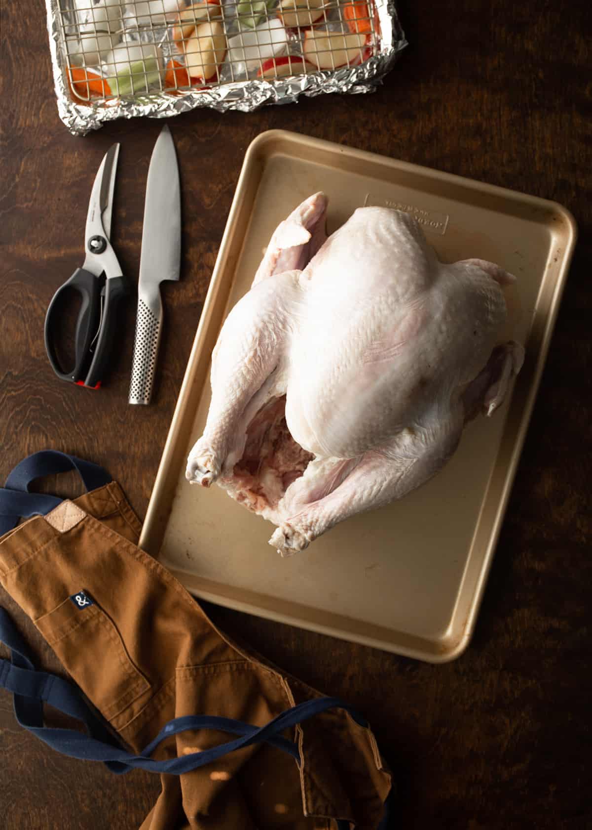 overhead image of uncooked turkey on a sheet pan