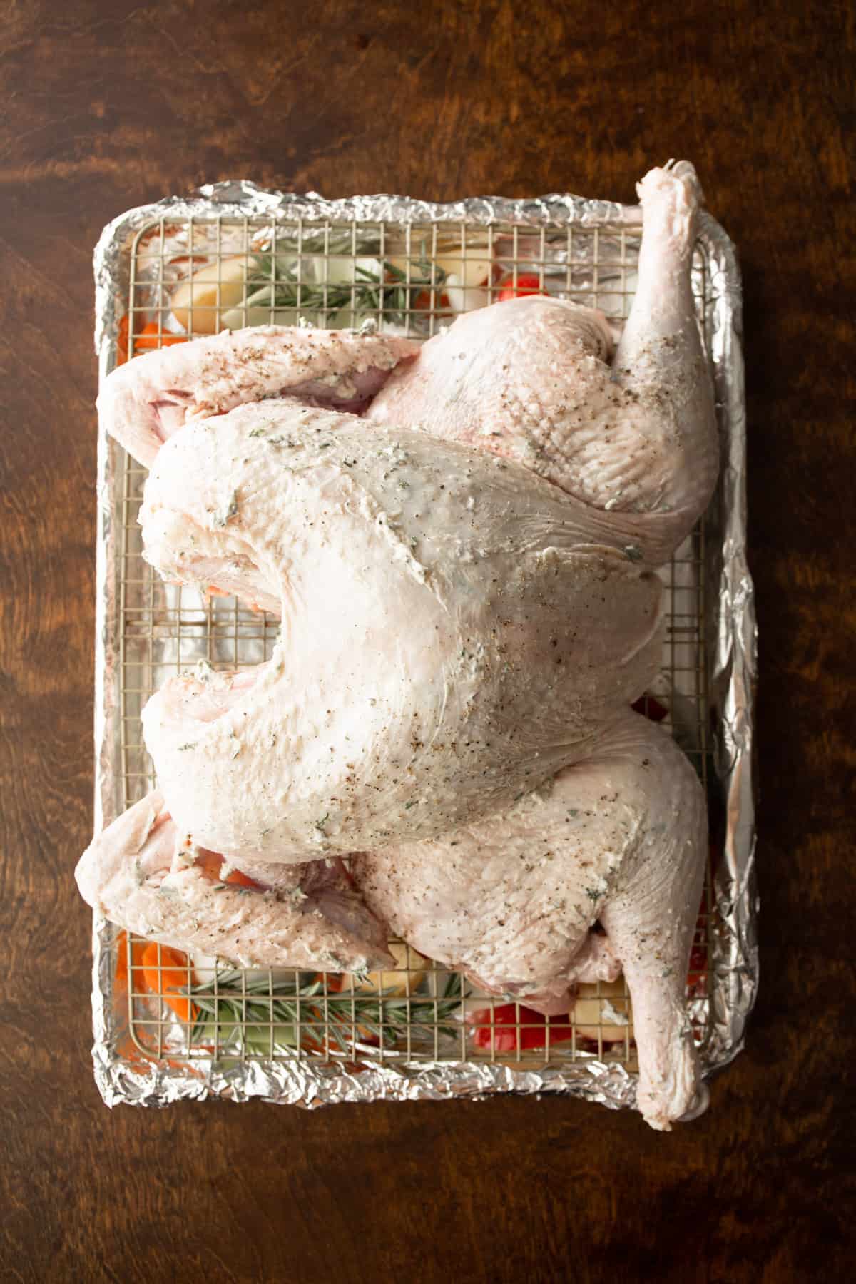 spatchcocked uncooked turkey on a sheet pan