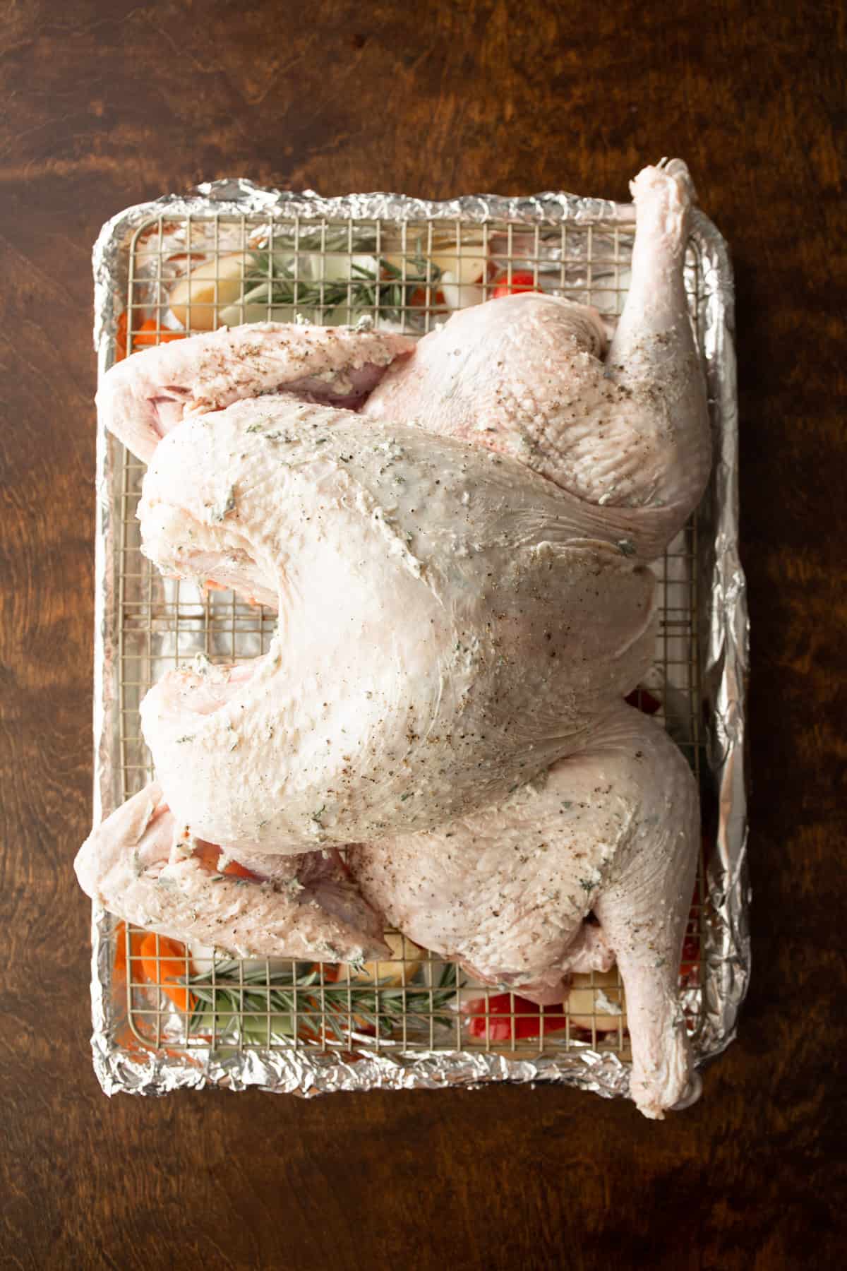 overhead image of a spatchcocked uncooked turkey on a sheet pan