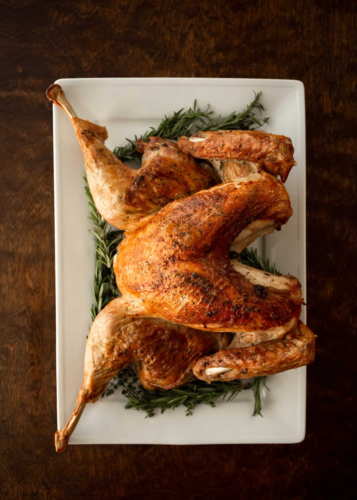 overhead image of a spatchcock turkey on a white tray