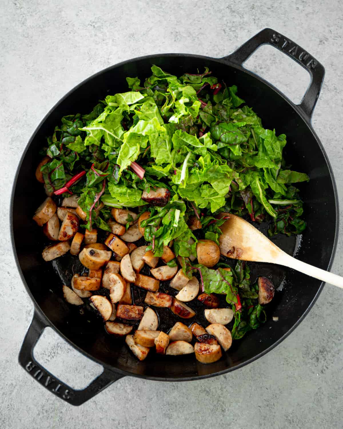 overhead image of chard and sausage in a cast iron skillet