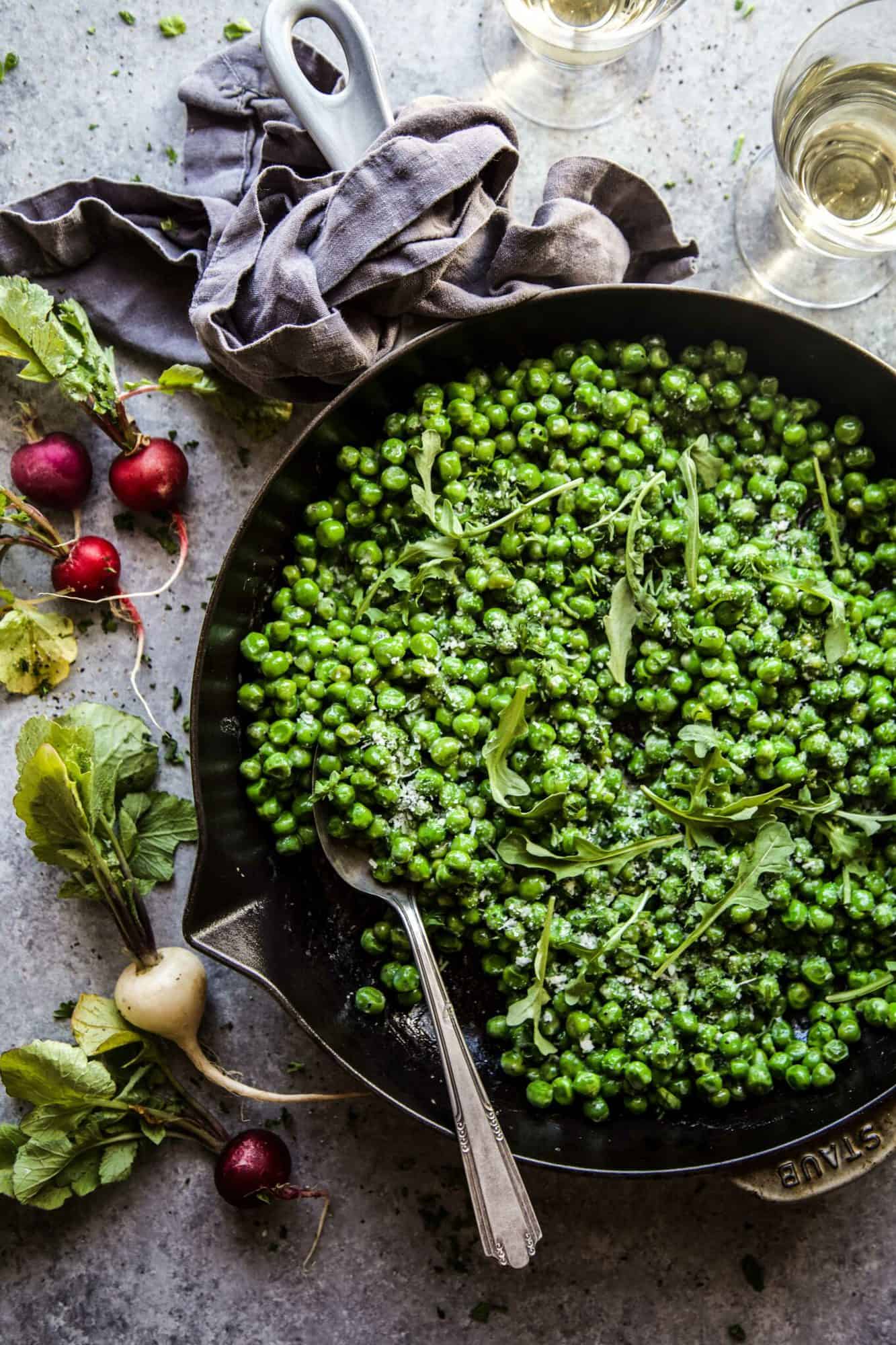 peas and greens in a cast iron skillet