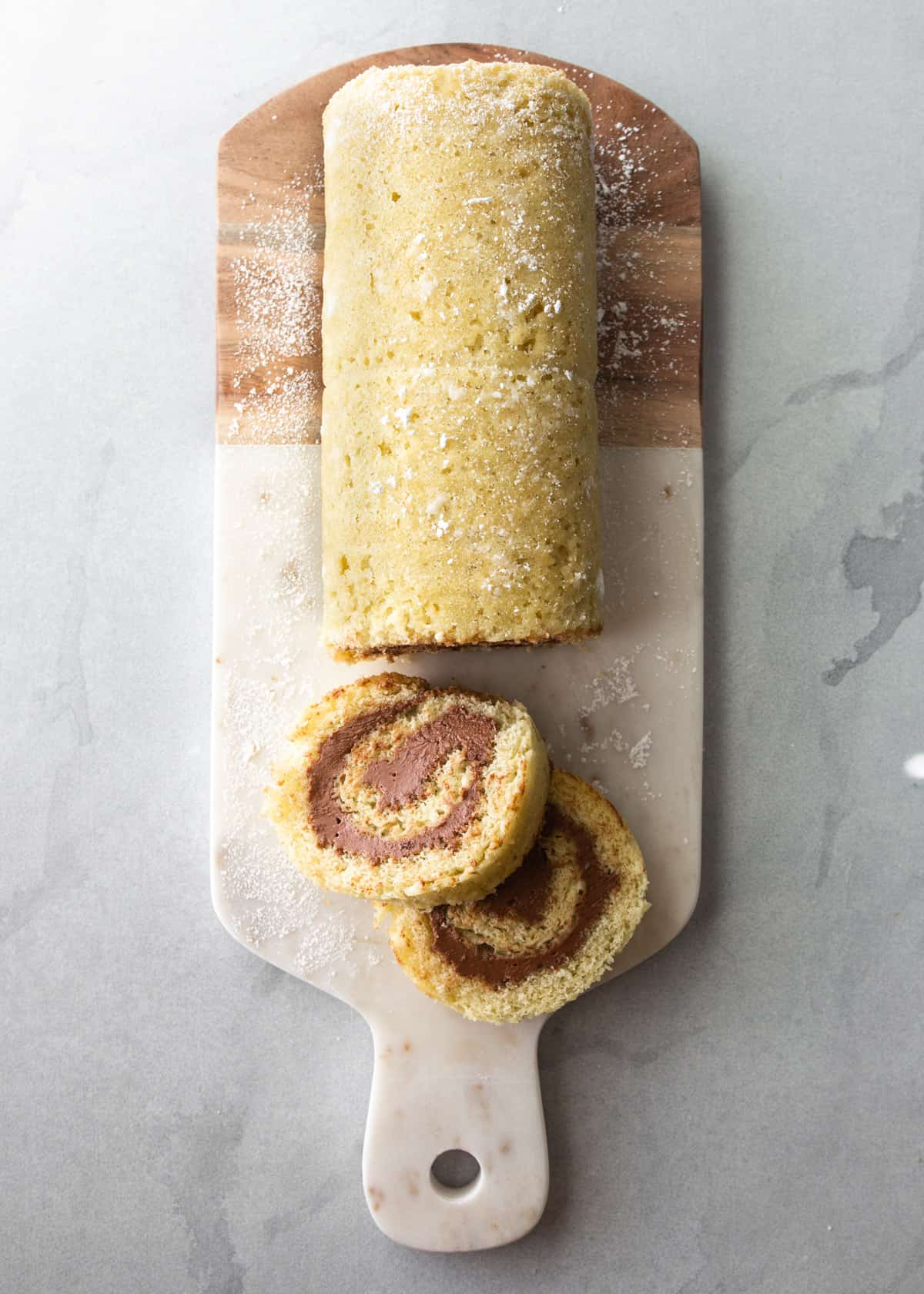 overhead image of a cake roll sliced on a cutting board