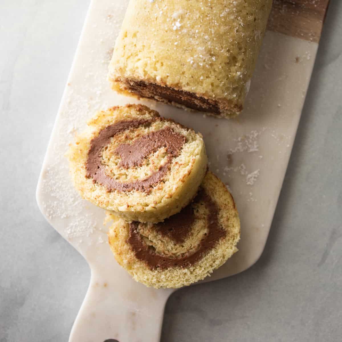 a vanilla cake roll on a cutting board