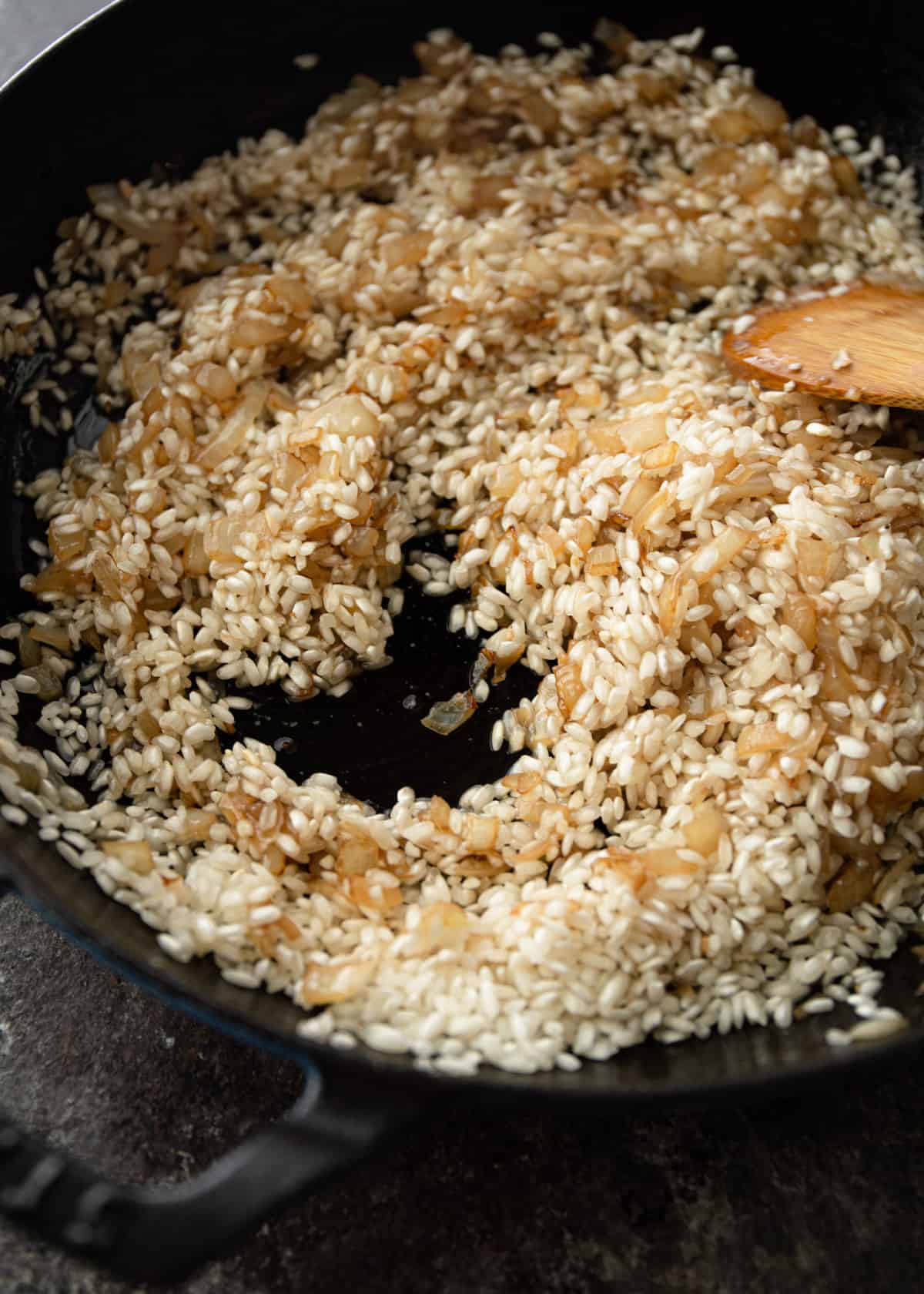 stirring rice in a cast iron skillet