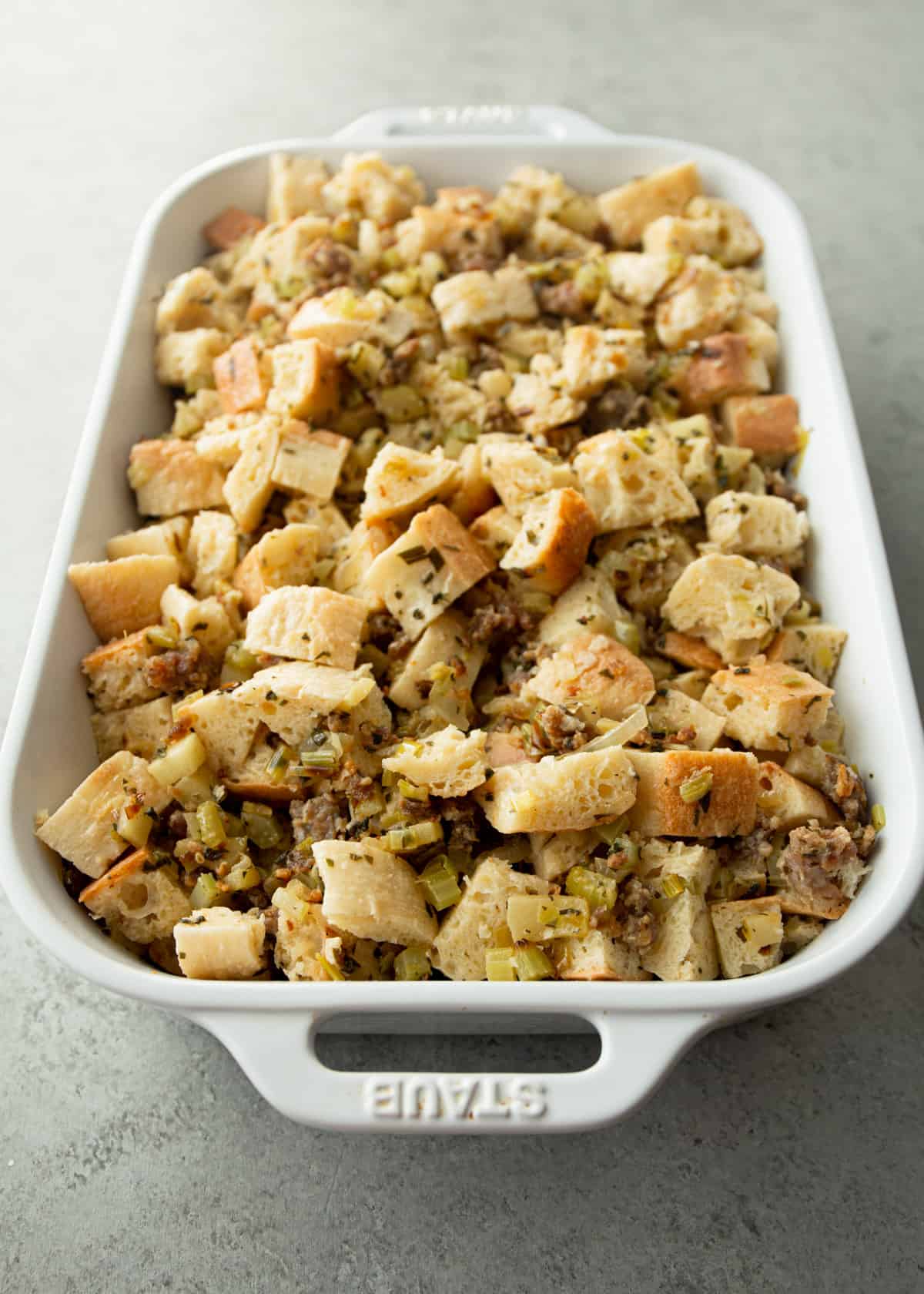 uncooked stuffing in a white baking dish