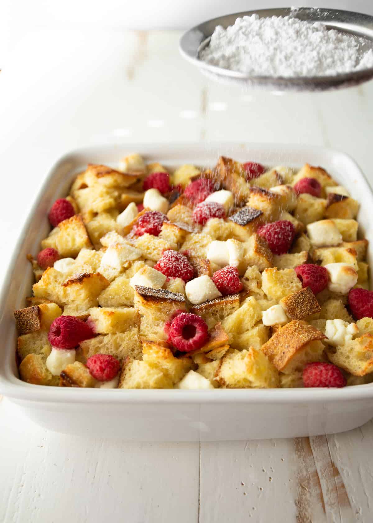 raspberry french toast bake in a white square baking dish