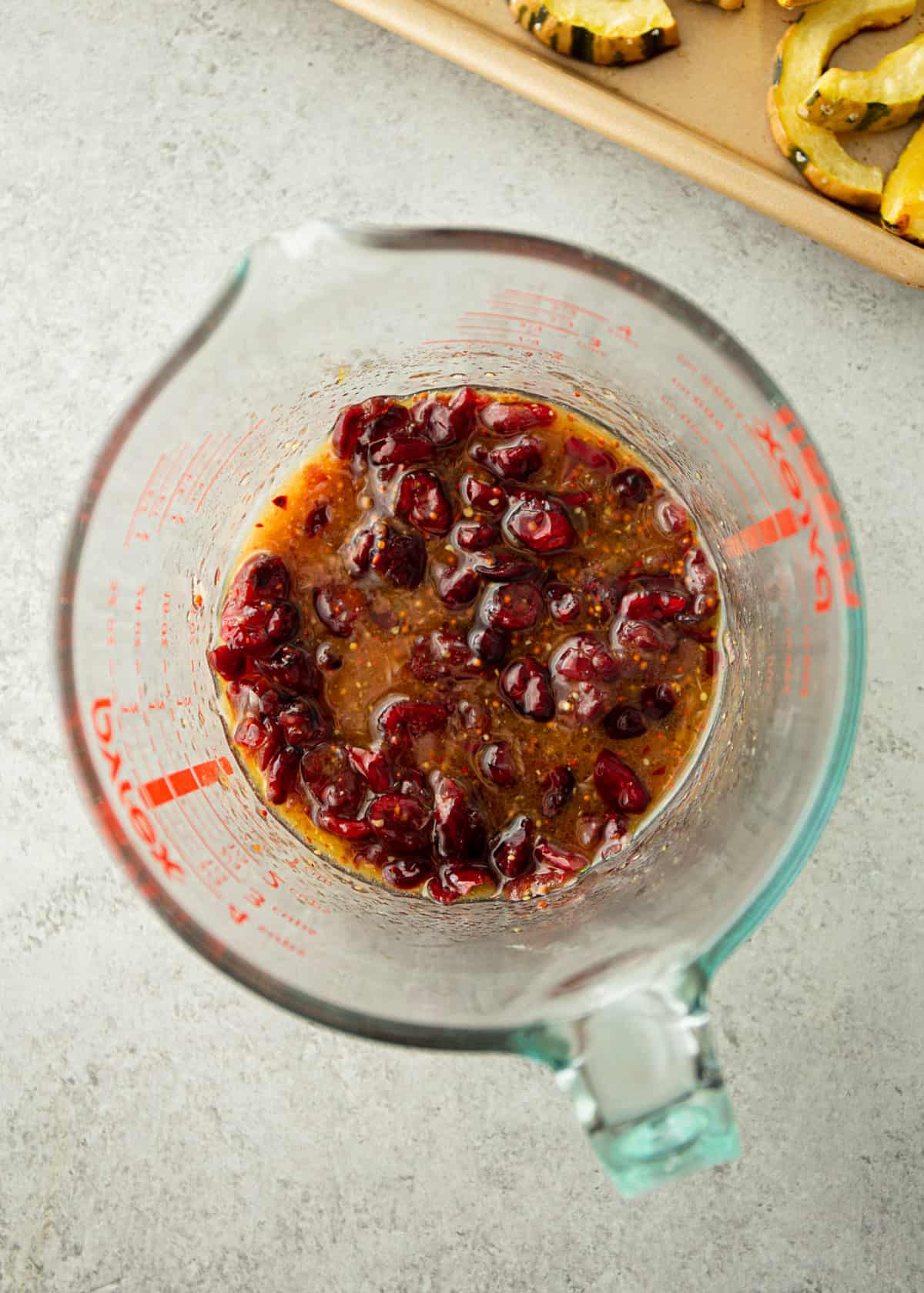 cranberries and sage in a glass measuring cup