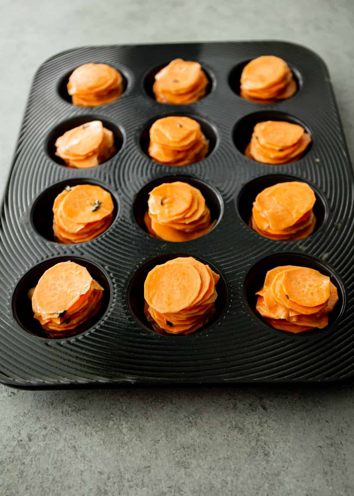 cooked potato stacks in a muffin tin