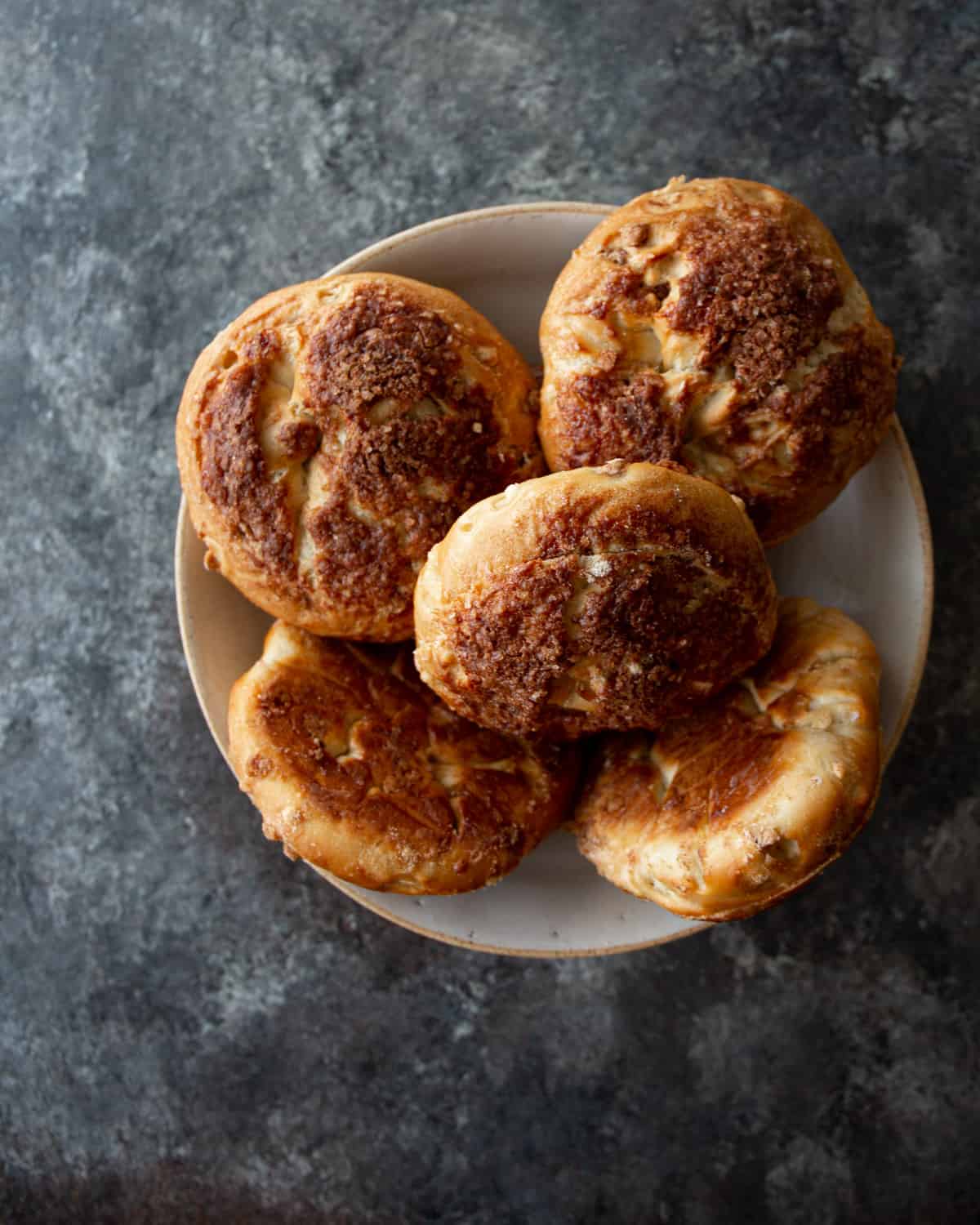 overhead image of cinnamon crunch bagels on a white plate