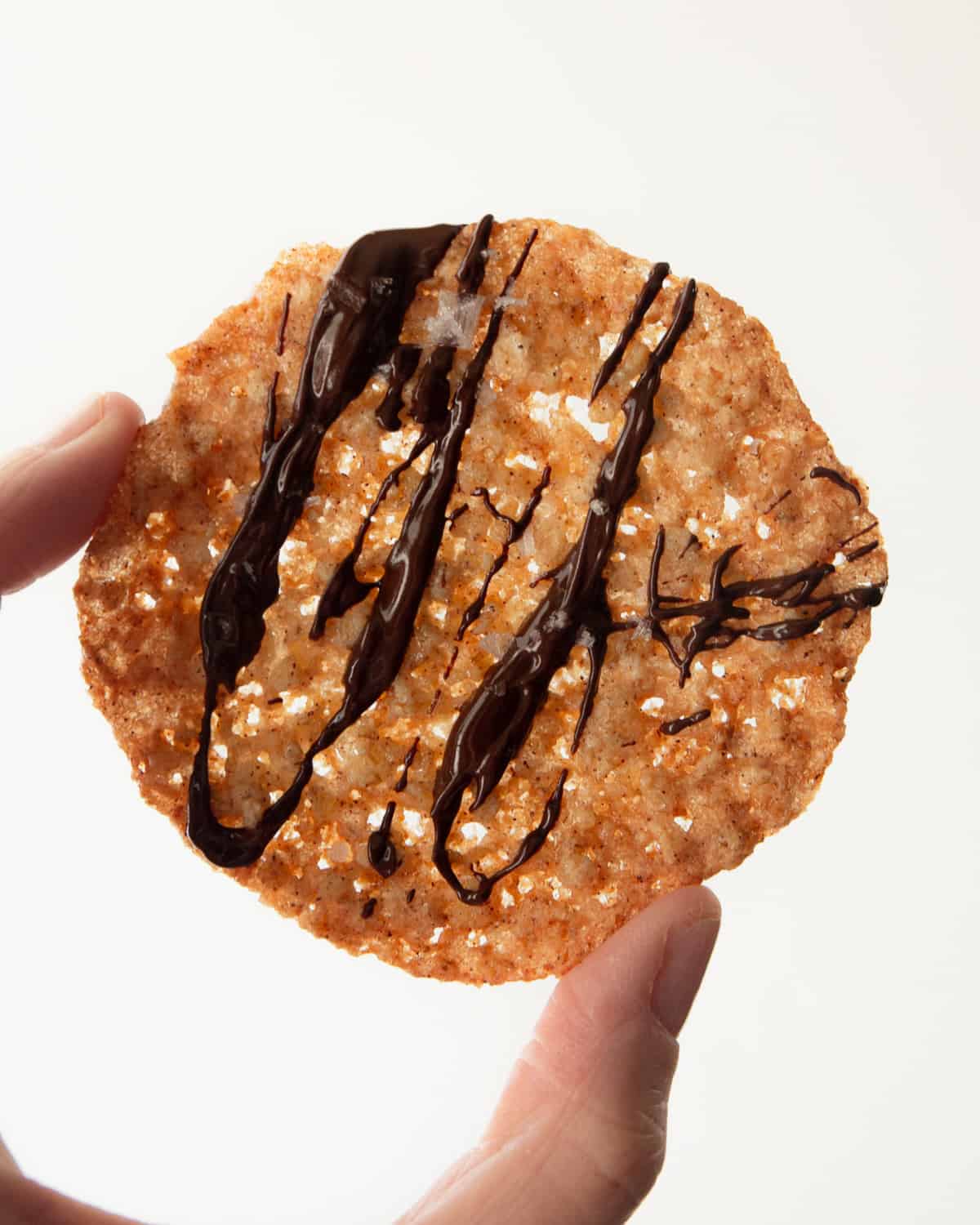 a oatmeal lace cookie with chocolate drizzle