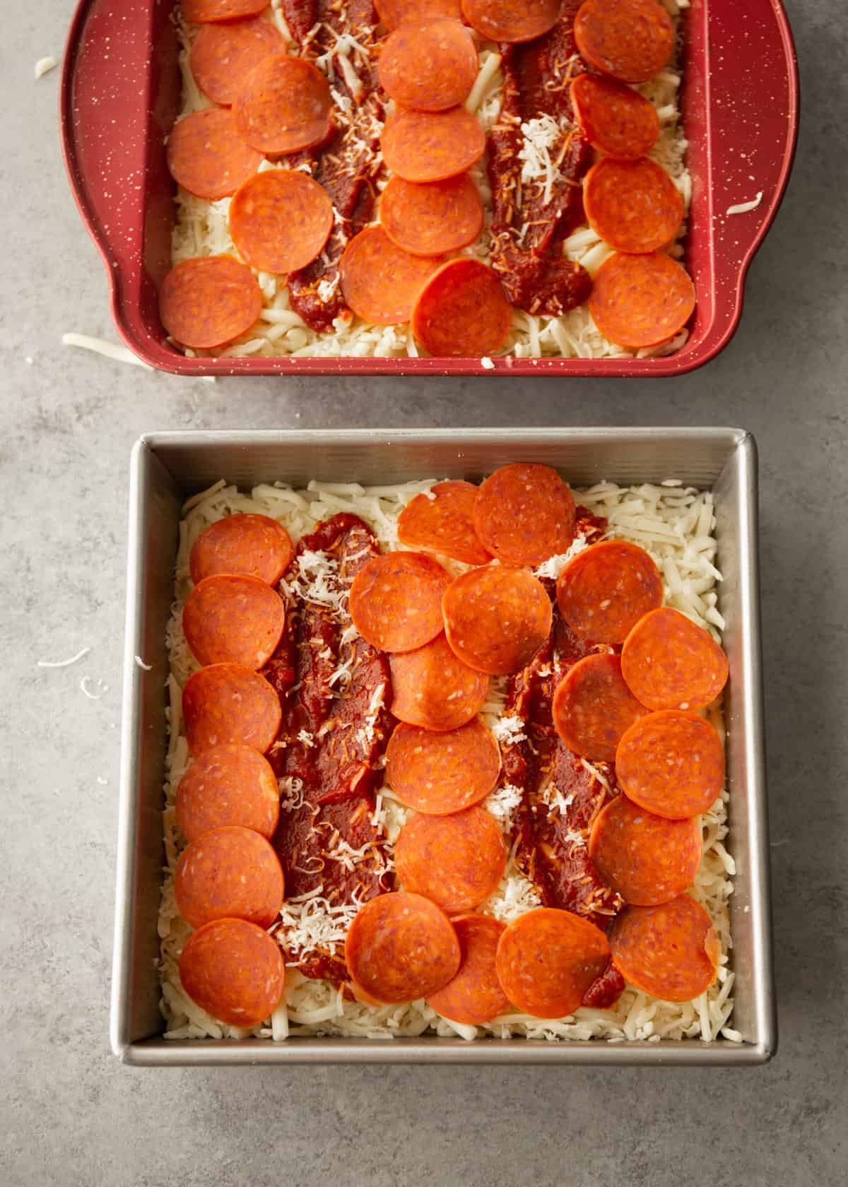 uncooked pepperoni pizza in a square baking pan