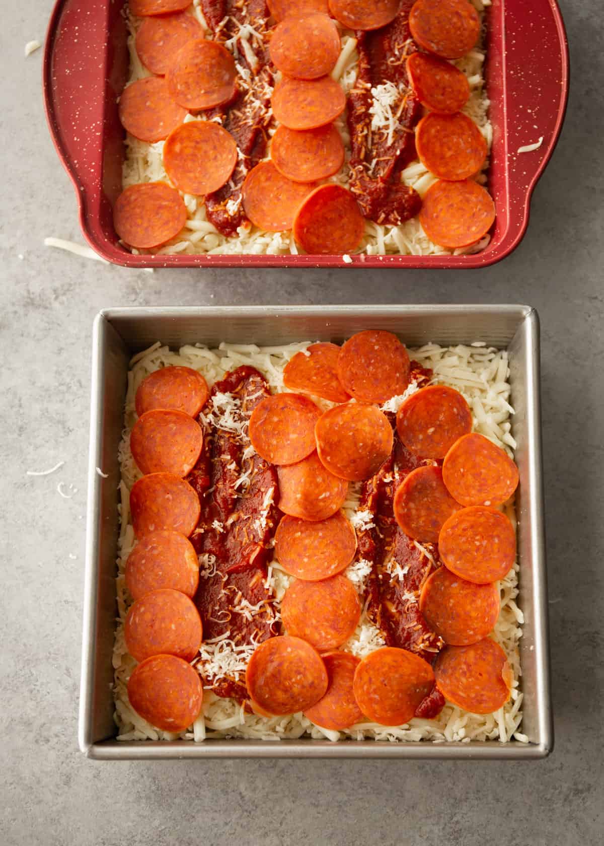 overhead image of uncooked pepperoni pizza in a square baking pan