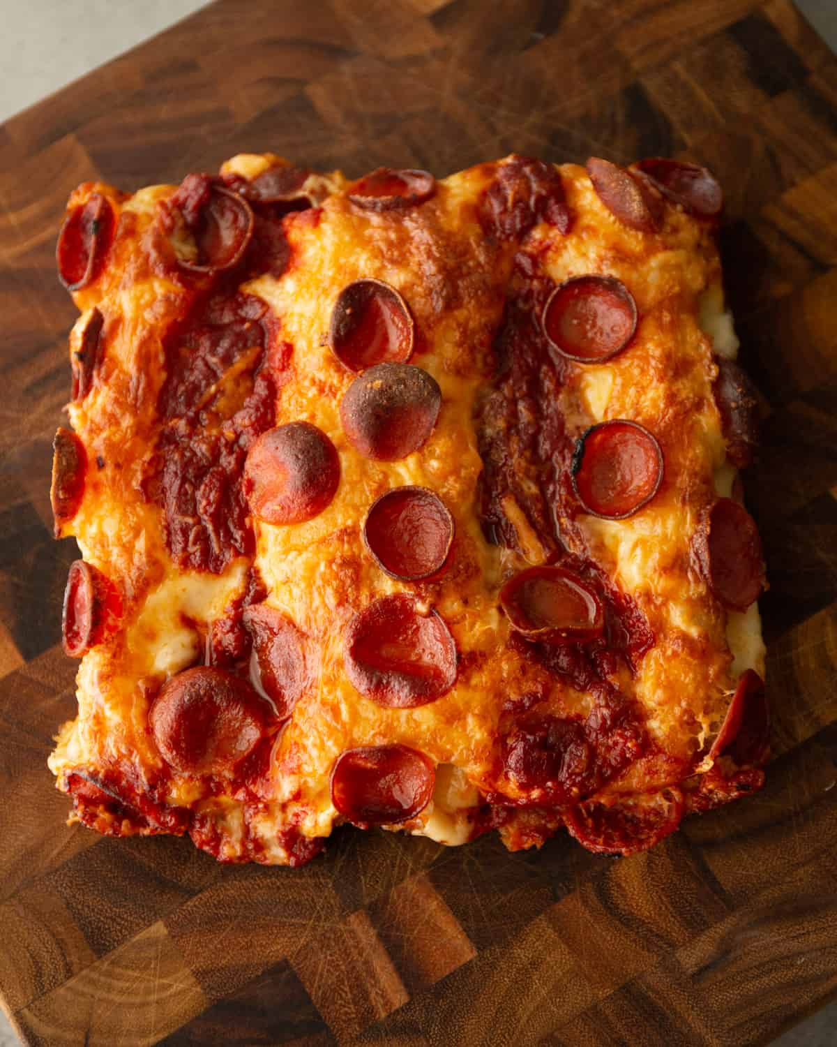 overhead image of detroit style pizza on a wooden table