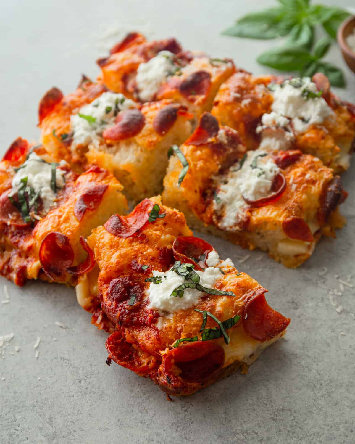 pizza cut into squares on a grey countertop