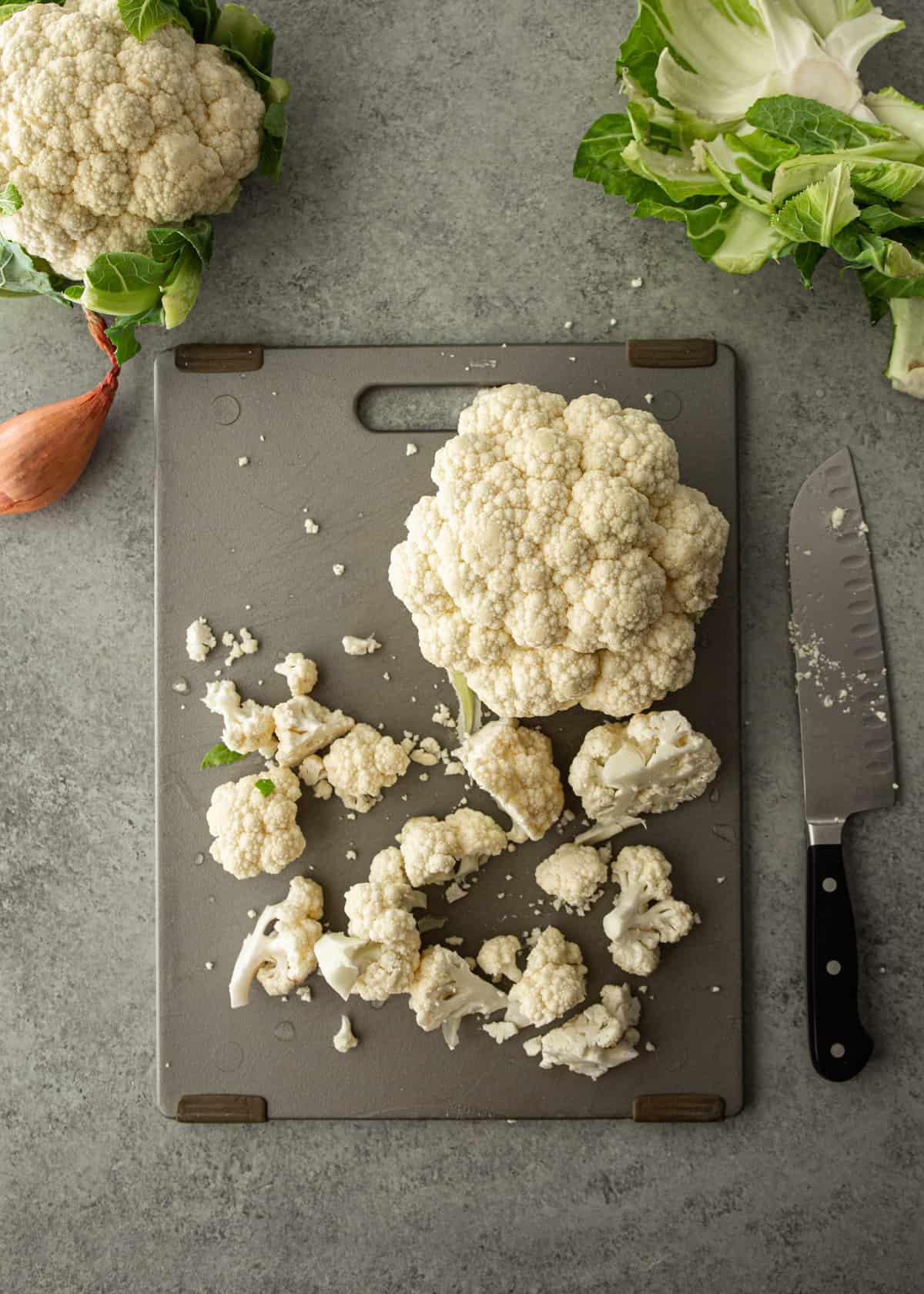 overhead image of cauliflower florets on a grey cutting board