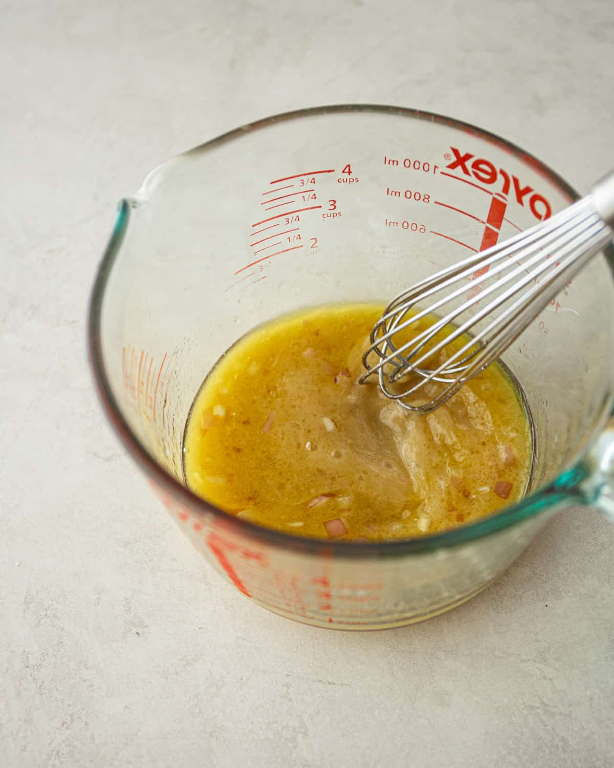 stirring vinaigrette in a glass measuring cup