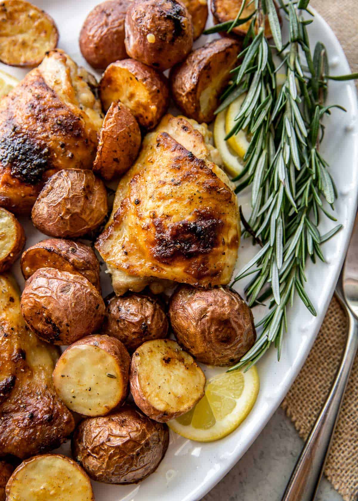 chicken and roasted potatoes on a white platter