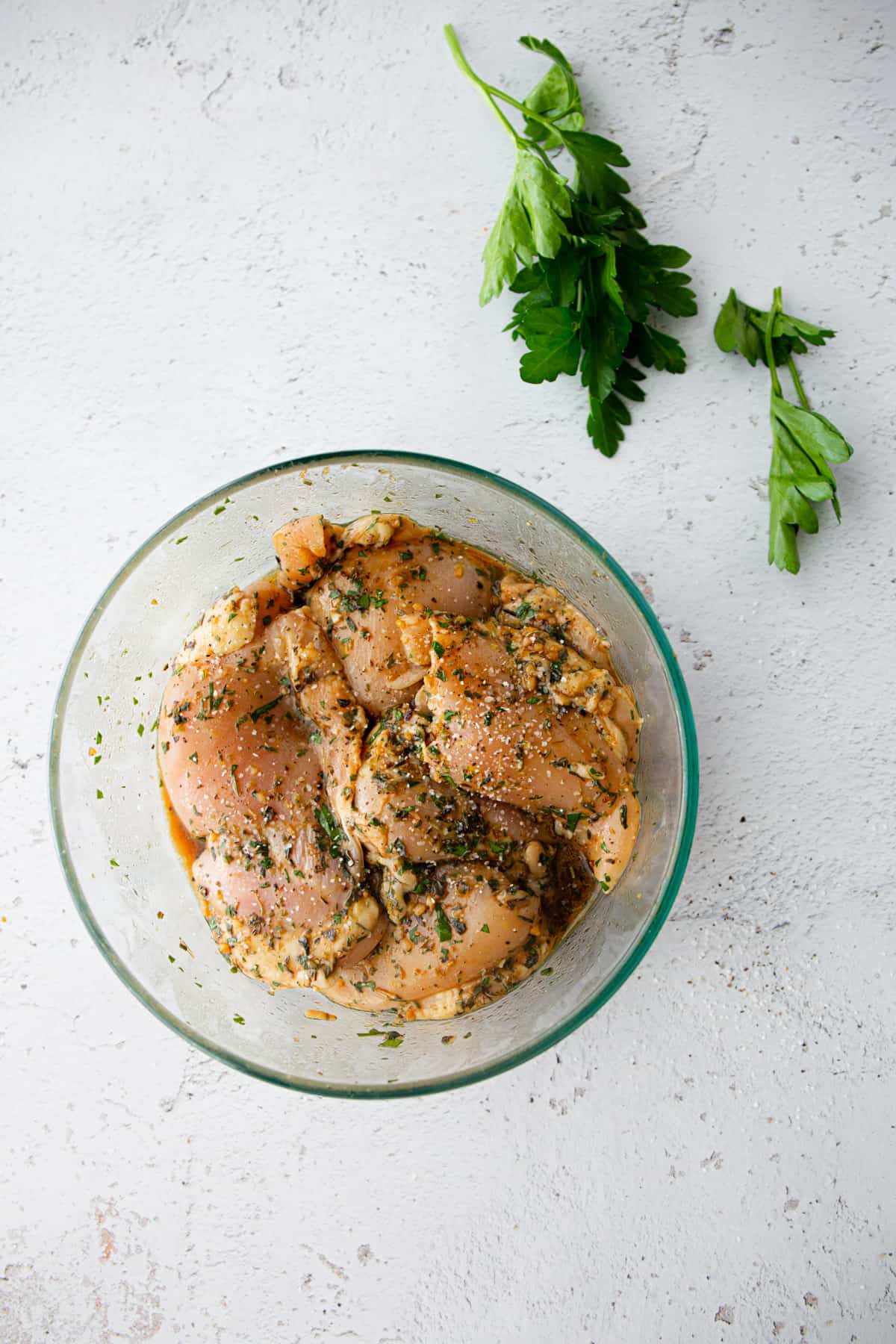 marinating chicken thighs in a clear glass bowl