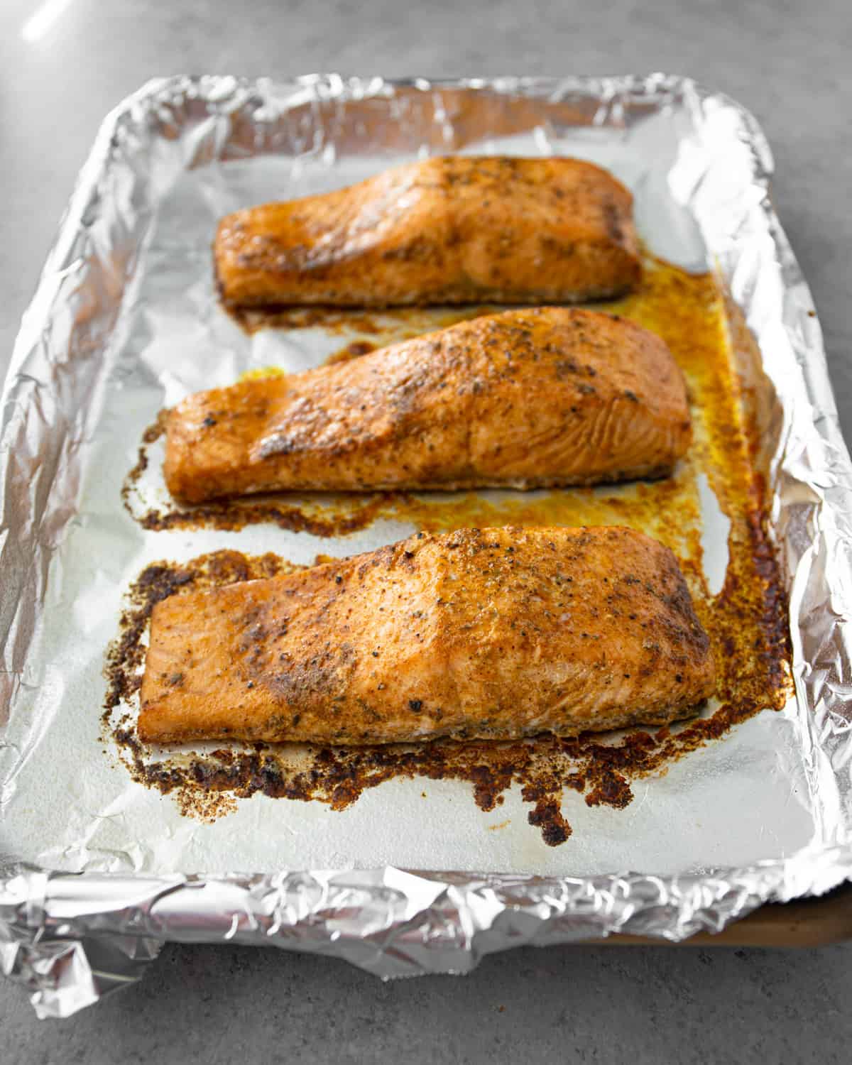 cooked salmon on a foil lined sheet pan