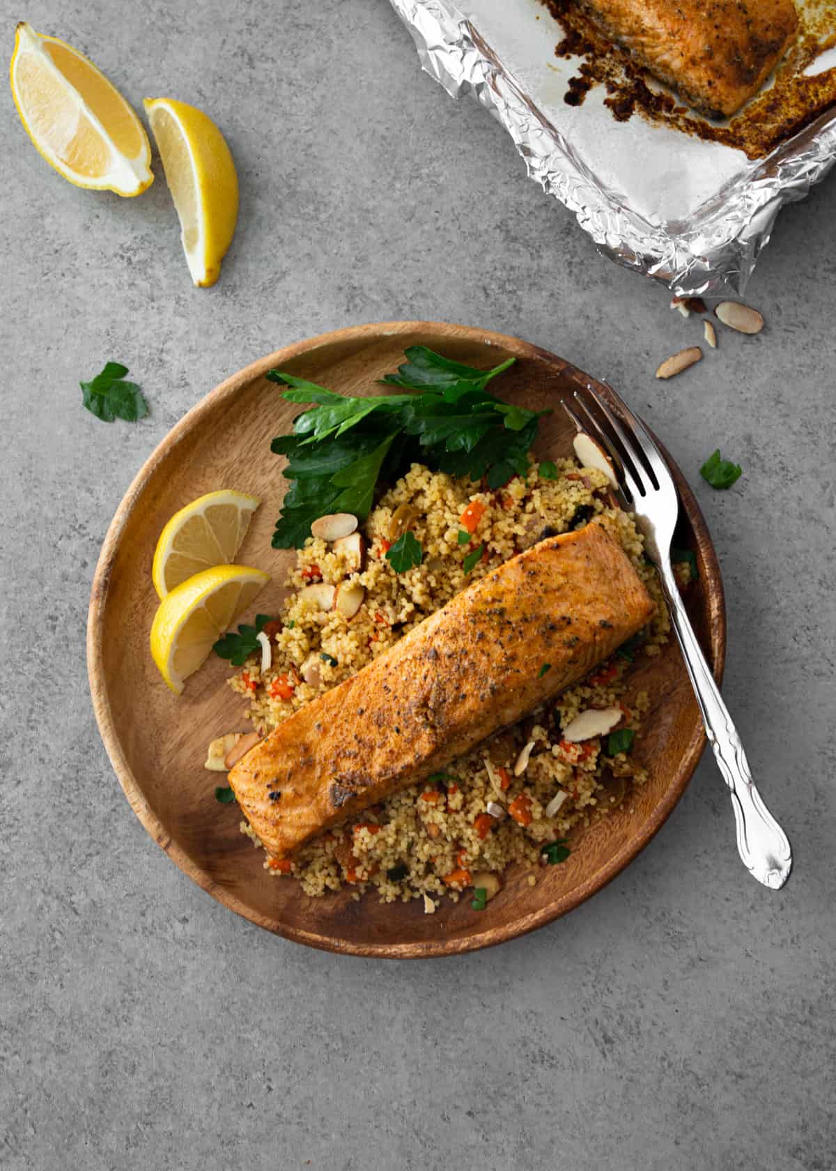 salmon and couscous on a round wooden plate