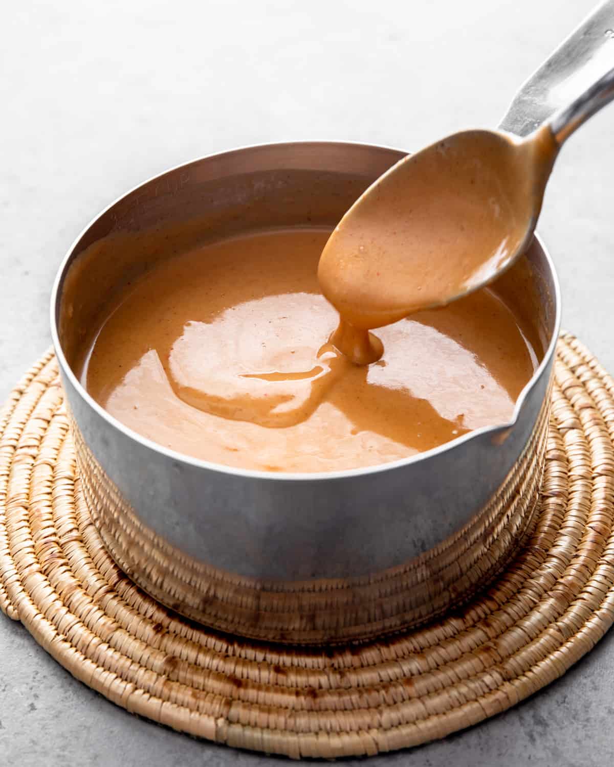 stirring peanut sauce in a saucepan 