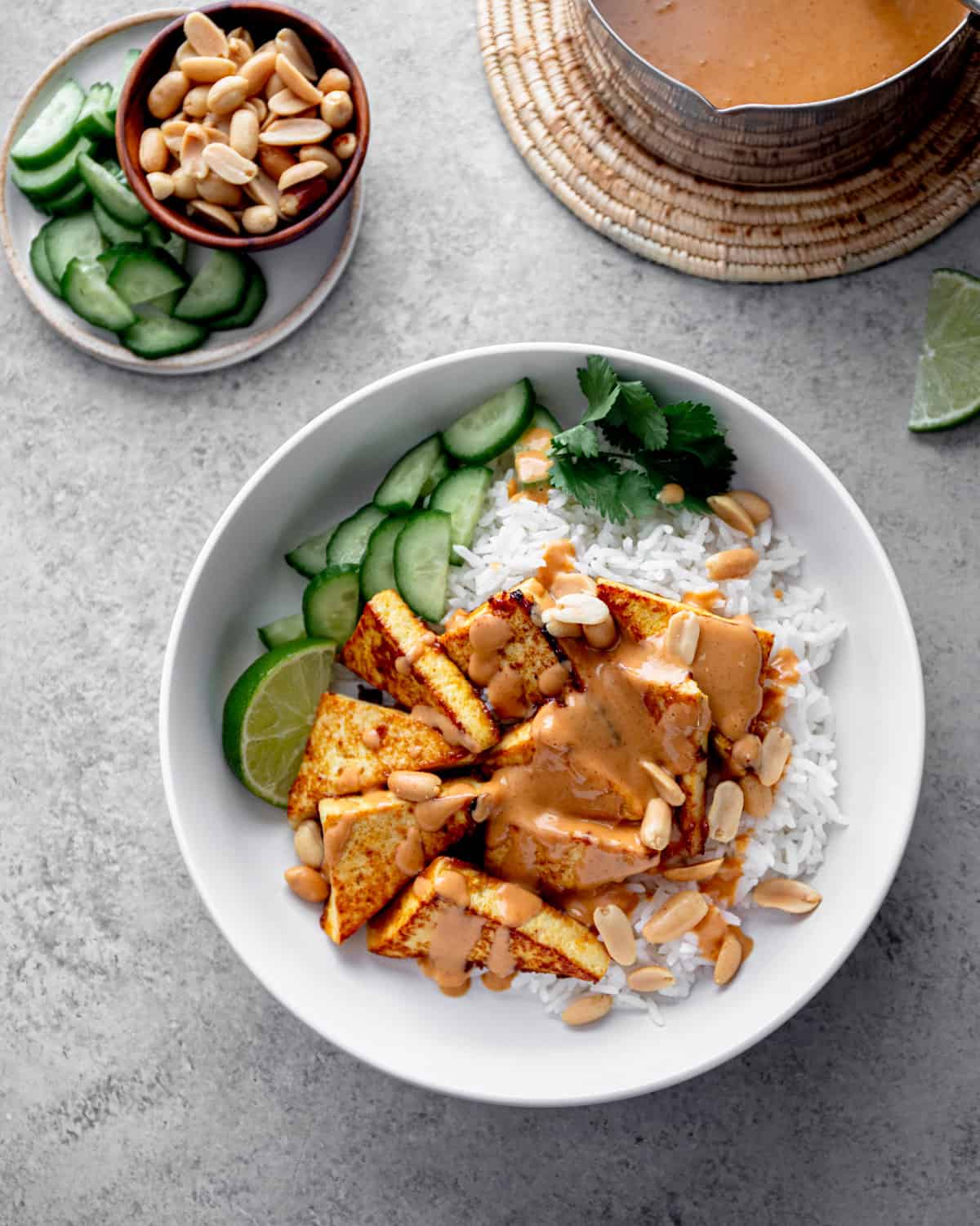 thai tofu and peanut sauce over rice in a white bowl