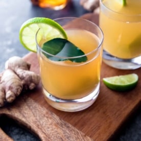 ginger lime hot toddy in a clear glass with a lime slice