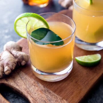 ginger lime hot toddy in a clear glass with a lime slice