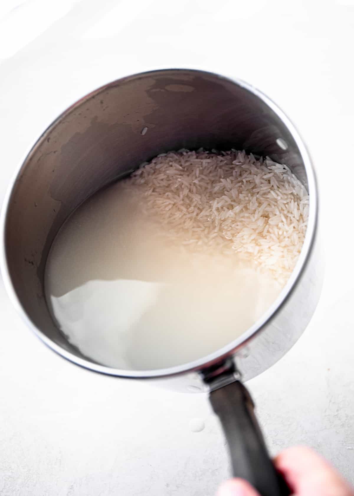water, rice and coconut milk in a saucepan
