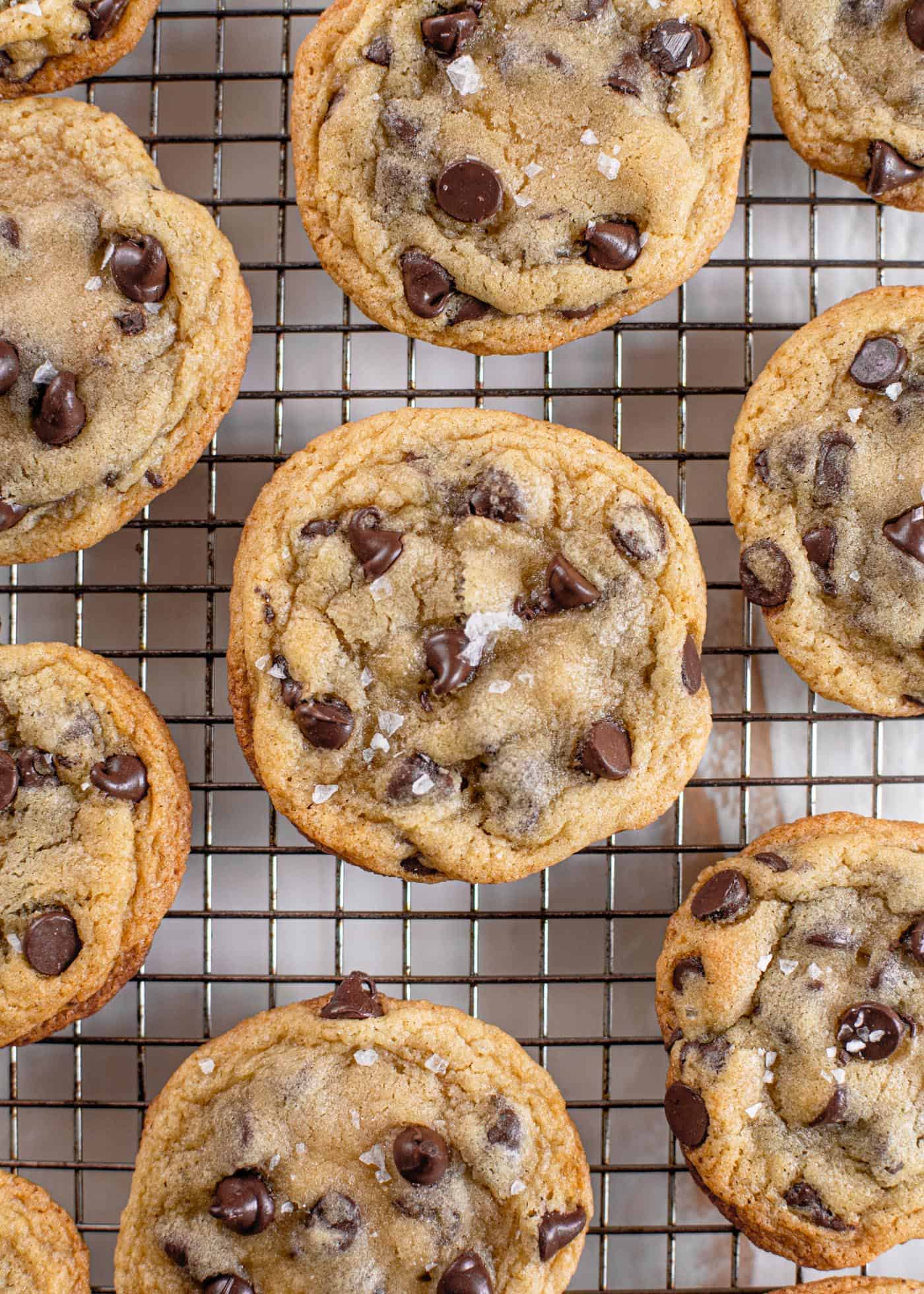 overhead image of crispy and chewy chocolate chip cookies on a cooling rack