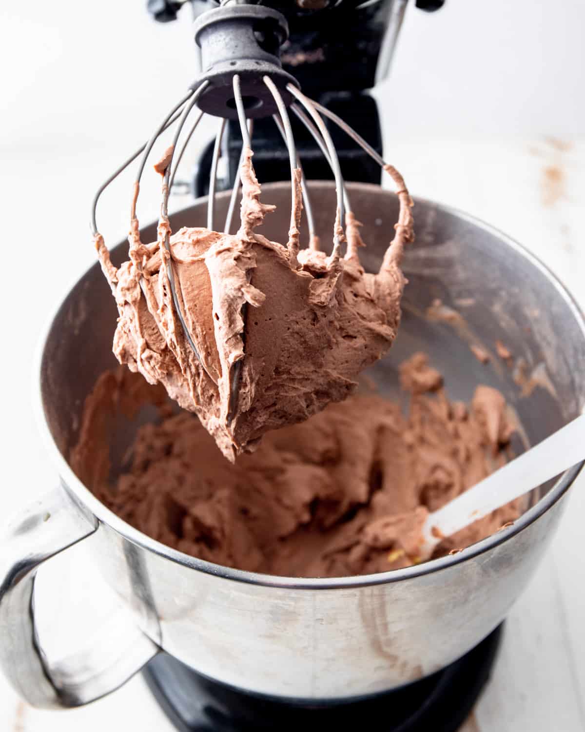 chocolate frosting on a whisk in a mixer
