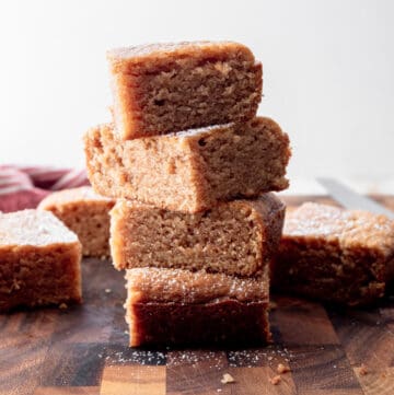 a stack of slices of peanut butter cake on a wooden cutting board