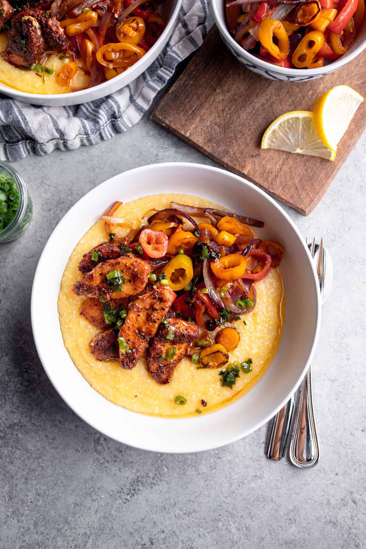 overhead image of fish, peppers and polenta in a white bowl