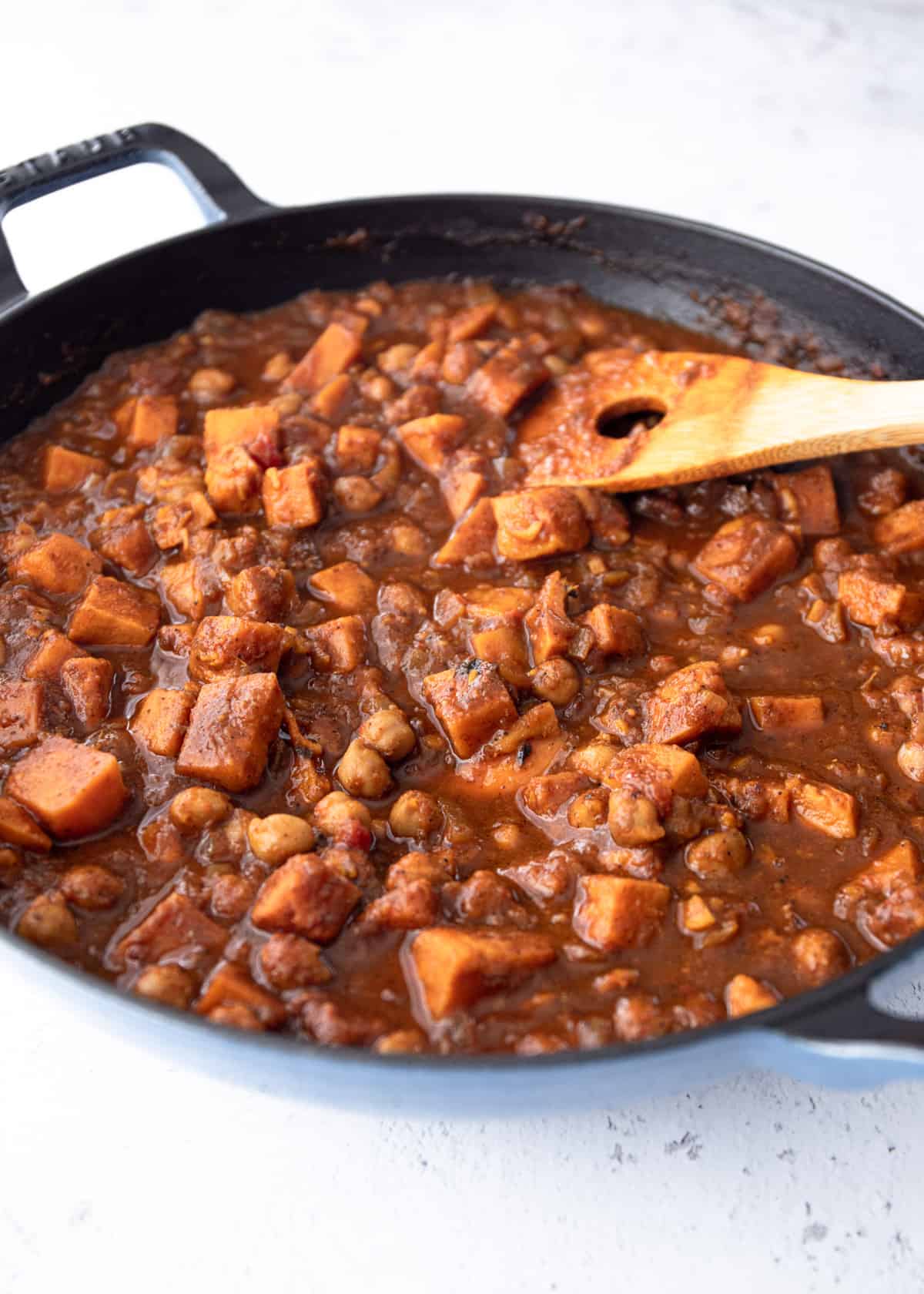 stirring masala in a cast iron skillet