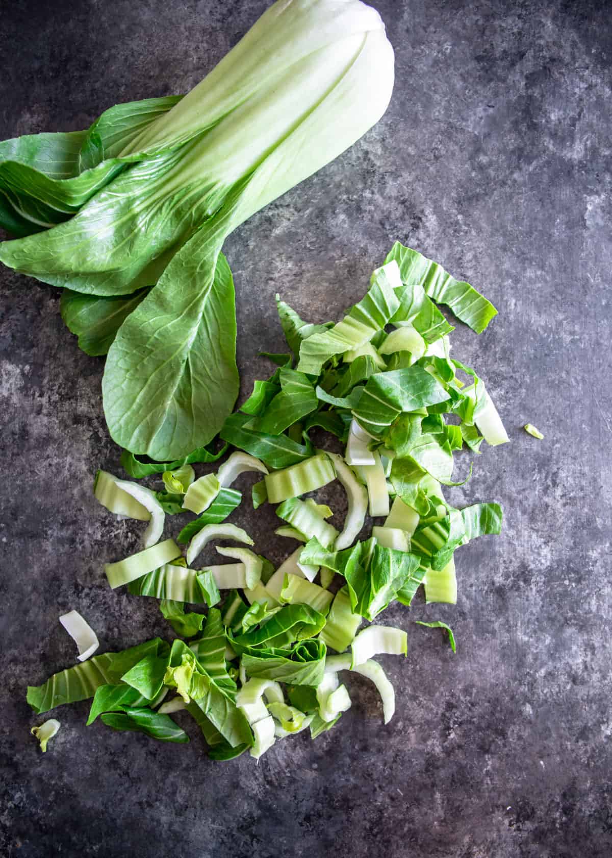 overhead image of chopped herbs on a grey countertop